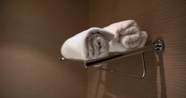 Toallas blancas limpias para parejas están listas para ser utilizadas en el baño del hotel. Servicio de spa y toallas en la ducha - Metraje, vídeo