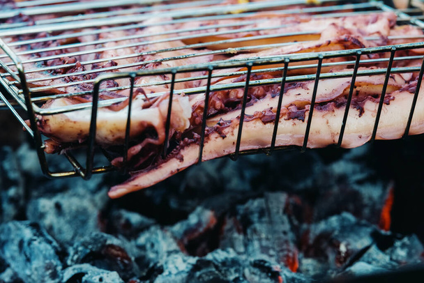 Octopus tentacles are cooked on a grill. - Foto, Imagem