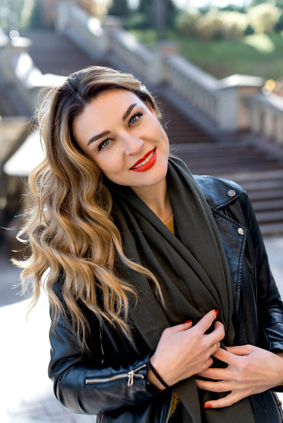 portrait of young beautiful woman with red lipstick and long blonde curled hair outdoors in park - Photo, image