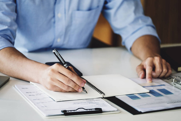 Finanzhaushaltsprüfung Ein männlicher Wirtschaftsprüfer verwendet einen Stift, um Budgets aufzuschreiben, um den Finanzbetrug des Unternehmens aufzuspüren - Foto, Bild