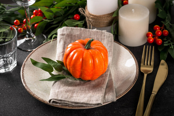 Ajuste de mesa de otoño con plato, calabaza y velas en mesa de madera. Comida de Acción de Gracias concepto de cena festiva. - Foto, imagen