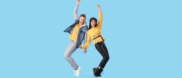 Happy dancing young couple on light blue background - Foto, immagini