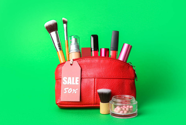 Laukku kosmeettisia valmisteita, tarvikkeet ja myynti tag vihreällä taustalla - Valokuva, kuva