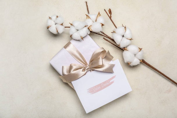 Caja de regalo con tarjeta y rama de algodón sobre fondo claro - Foto, imagen