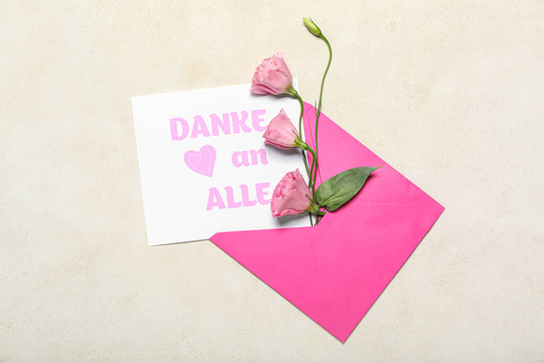 Umschlag, Karte mit dem Text DANKE AN ALLE und Eustoma-Blumen auf hellem Hintergrund - Foto, Bild
