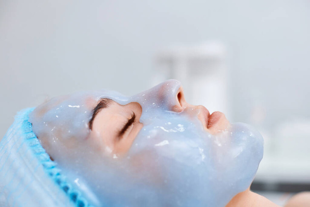 beautiful woman with blue alginate mask on face in the spa salon. close-up - Foto, immagini