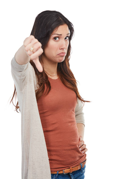 Making her disapproval clear. Portrait of an unhappy young woman showing a thumbs down in studio - Foto, Imagem