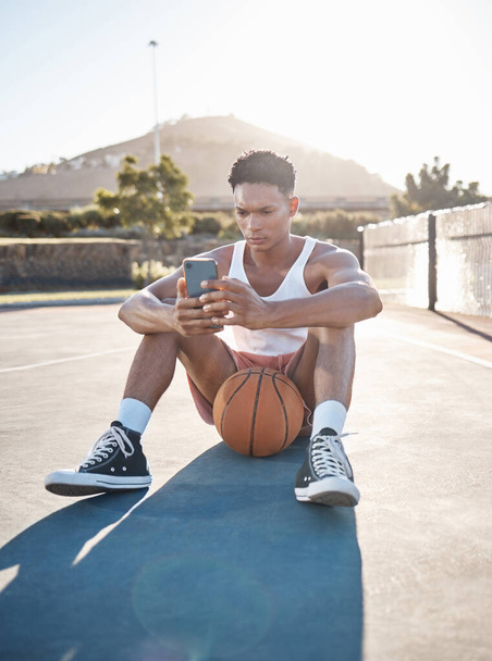 Telefone, fitness e basquete homem relaxar digitando resultados de treinamento no aplicativo móvel, jogos ou ler atualização do blog. Jogador de basquete adolescente no chão e smartphone 5g usando telefone para mídias sociais. - Foto, Imagem