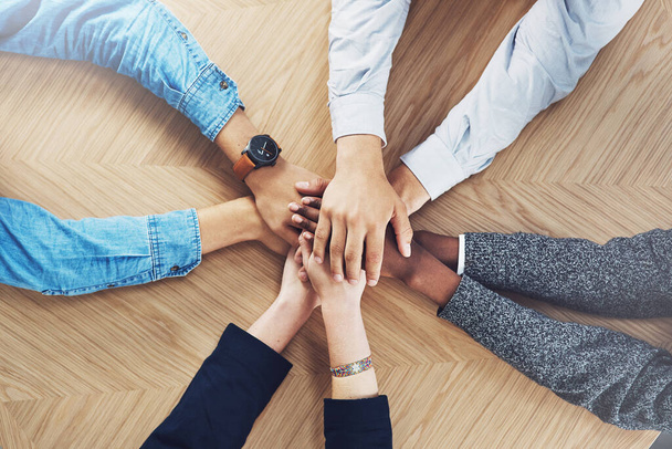 On a united mission to make it happen. High angle shot of a group of unidentifiable businesspeople joining their hands together in unity - Foto, Imagem