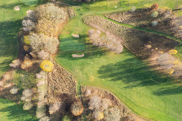 Aerial panoramic view of beautiful autumn morning, golf course, river, multicolored trees and green grass, warm sunlight, shadows - Photo, image