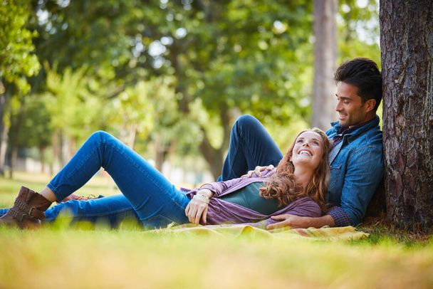 Conoscersi un po 'di piu'. una giovane coppia sorridente che si gode la giornata insieme al parco - Foto, immagini
