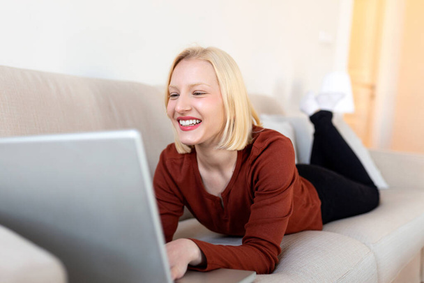 Молодая женщина-фрилансер смотрела видео в блоге на нетбуке у себя дома. Молодая бизнесвумен работает над laptop.Freelancer - Фото, изображение