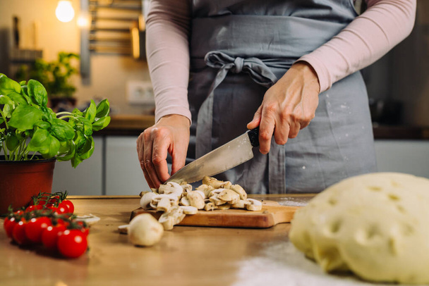 close up of woman cutting mushroom using knife in home kitchen - Fotoğraf, Görsel