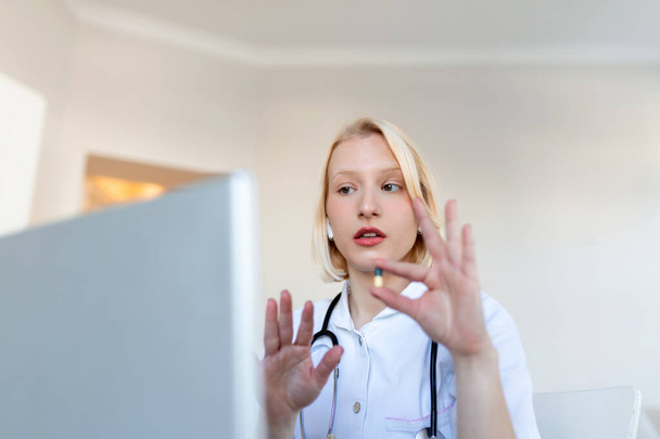 Жінка-лікар, яка пройшла онлайн-терапію зі своїм пацієнтом, дає їм поради під час використання телемедицини як нового нормального під час пандемії COVID-19.
 - Фото, зображення