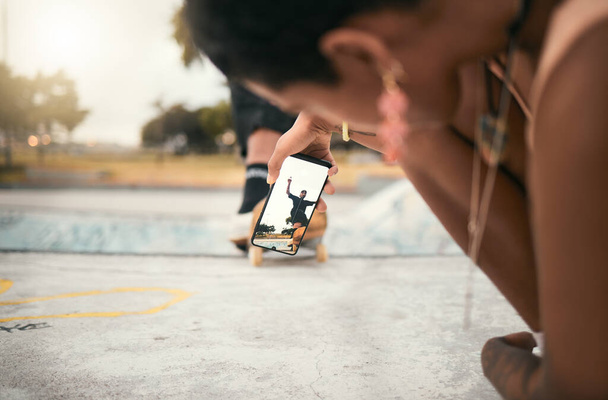 Phone, skate and photograph with a woman recording a man skater at the skatepark for fun or recreation. Mobile, skating and picture with a male athlete riding a board while a friend is filming. - Photo, Image