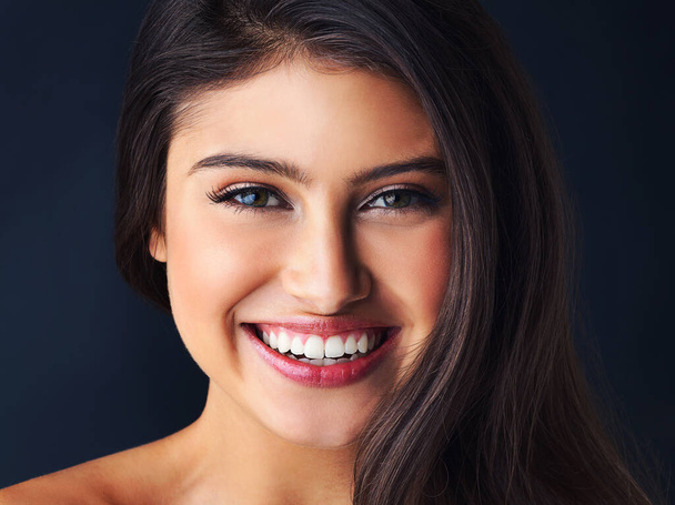 Words cant describe that smile. Cropped portrait of a gorgeous young woman posing against a dark background - Fotoğraf, Görsel