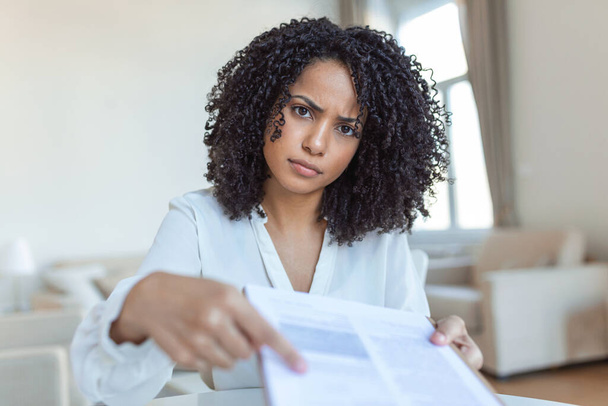 Oříznutý pohled na ženskou právničku, jak dává dokument a pero, zatímco sedí na pracovišti s nimi figurka na rozmazaném pozadí - Fotografie, Obrázek