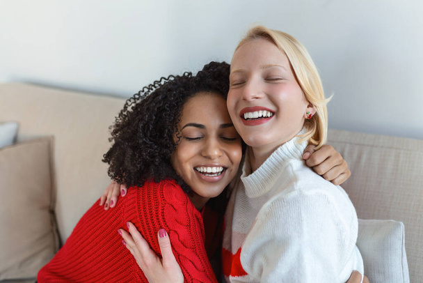 Candid diverse girls best friends embracing standing indoors, close up satisfied women face enjoy tender moment missed glad to see each other after long separation, friendship warm relations concept - Photo, Image