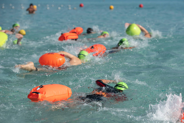競技中は海でフリースタイルで泳ぐ選手たち。海の中の水泳 - 写真・画像