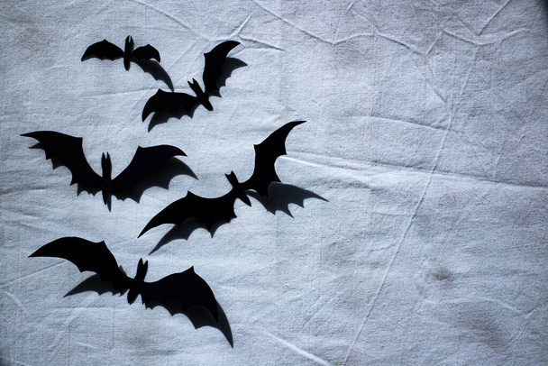 Halloween-Party-Konzept. Papiersilhouetten schwarzer Fledermäuse auf einer schmutzigen Leinwand. Flacher Stapel, Platz für Text. - Foto, Bild