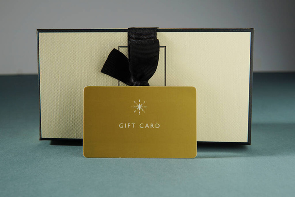 Желтая подарочная карта и подарочная коробка на зеленом фоне. подарочная карта или подарок - Фото, изображение