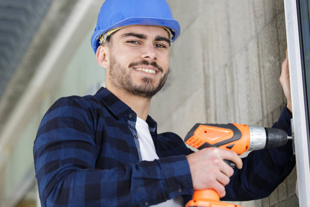 working man builder using electric screwdriver indoors - Photo, Image