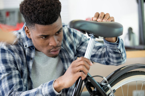 man adjusting a bicycle seat - Foto, imagen