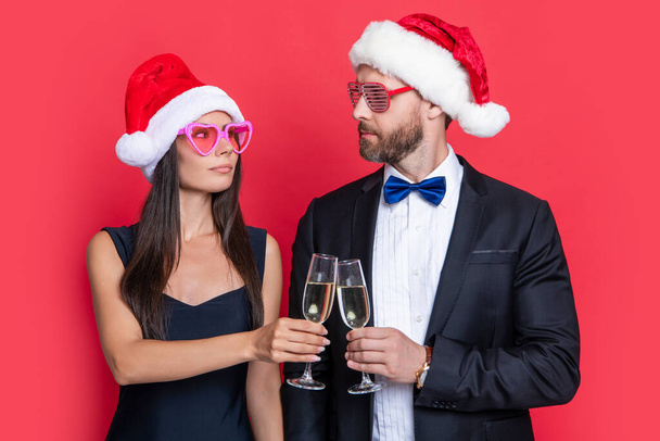 cheers. christmas couple celebrate party isolated on red. celebrate christmas party with couple. merry christmas to couple at party in studio. couple celebrate christmas. lets celebrate holiday party. - Fotografie, Obrázek