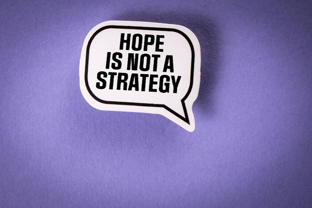 Η ελπίδα δεν είναι στρατηγική. Φούσκα ομιλίας με κείμενο σε μωβ φόντο. - Φωτογραφία, εικόνα
