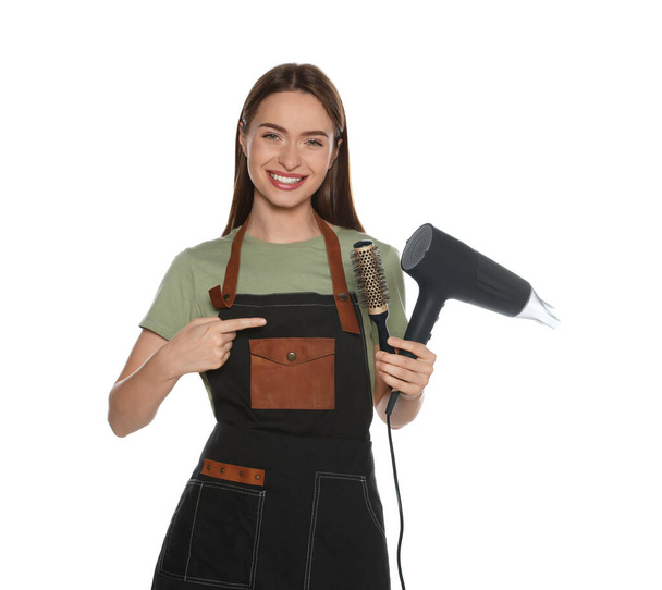 Portrait of happy hairdresser with hairdryer and round brush on white background - Photo, Image