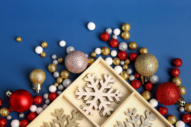 Holzschachtel mit wunderschönem Weihnachtsschmuck auf blauem Hintergrund, Nahaufnahme - Foto, Bild