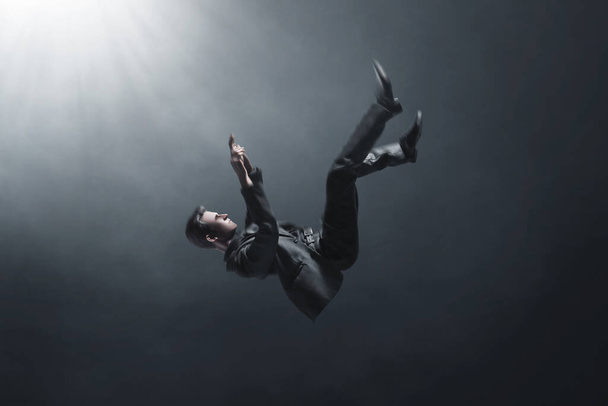 Falling business man 3d illustration on dark background  - Valokuva, kuva