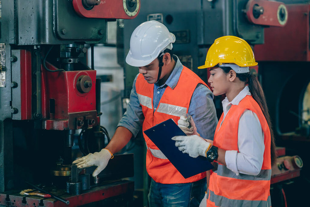inżynier męski szkolenia i check machine z zespołem pracownic w fabryce przemysłu metalurgicznego - Zdjęcie, obraz