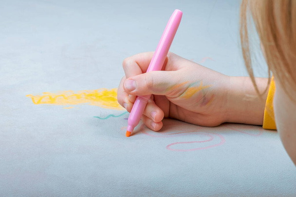 Rysunek dłoni dziecka z różowym piórem z filcu na szarej tapicerce kanapy. codziennego życia brudne plamy do mycia i czyste pojęcie. Wysokiej jakości zdjęcie - Zdjęcie, obraz