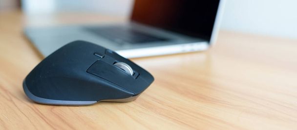Ergonomic vertical mouse with laptop computer on adjustable desk at workplace, prevention wrist pain. De Quervain s tenosynovitis, Intersection Symptom, Carpal Tunnel or Office syndrome concept - Photo, Image