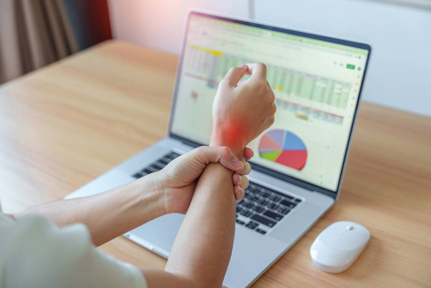 Woman having wrist pain when using mouse during working long time on workplace. De Quervain s tenosynovitis, ergonomic, Carpal Tunnel Syndrome or Office syndrome concept - Photo, Image