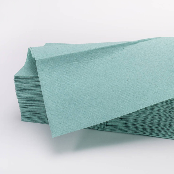 Fragment stosu zielonych jednorazowych ręczników papierowych, zbliżenie, selektywne skupienie. Akcesoria do czyszczenia i higieny - Zdjęcie, obraz