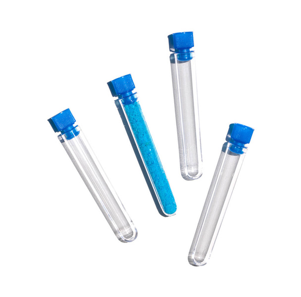 Test tüpünde kapsüllü mavi pullu kimyasal madde, bakır (II) sülfat. Laboratuvar masasında kozmetik kimyasallar var.. - Fotoğraf, Görsel