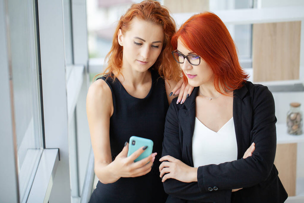 Deux femmes d'affaires rousses au bureau enregistrent un blog vidéo. - Photo, image