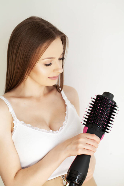 Красивая длинноволосая женщина сушит волосы в ванной комнате. - Фото, изображение