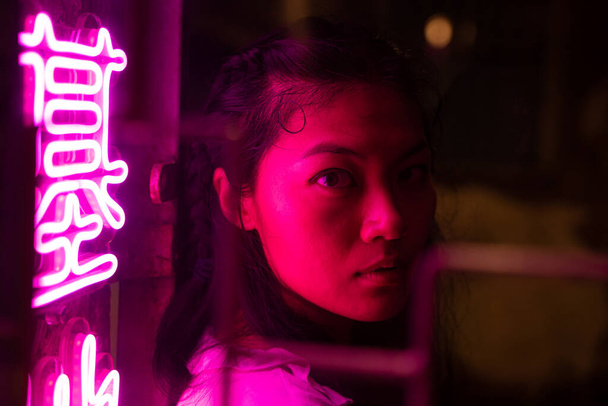 sérieux asiatique femme illuminé par néon lumières dans l 'rue l' nuit - Photo, image