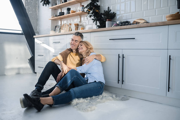Счастливая пара. Счастливая пара, сидящая на кухне и выглядящая радостно - Фото, изображение