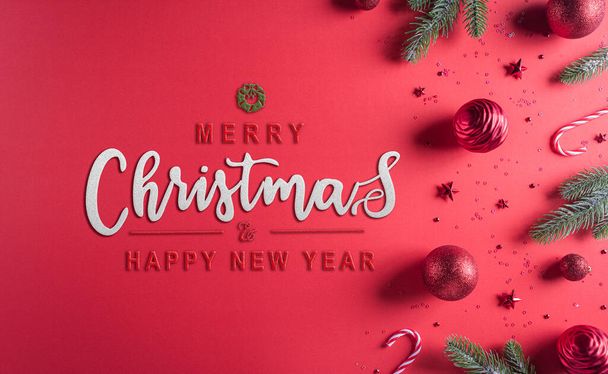 Christmas composition. Fir tree branches, red ball and stars on red background. Christmas, winter, new year concept. Flat lay, top view, copy space for text. - Foto, Imagem