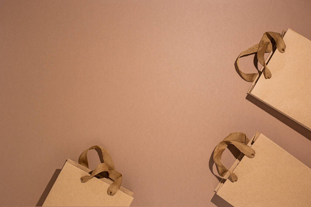 Verpakkingszakken voor geschenken, ambachtelijk bruin op een bruine kartonnen achtergrond. Bovenaanzicht, vlak lay. - Foto, afbeelding