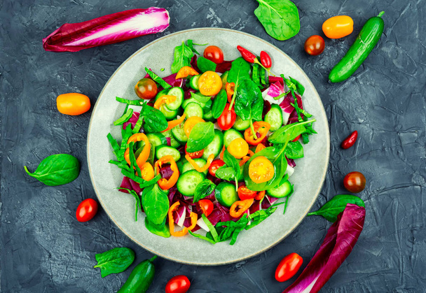 Letní vitaminový salát z rajčat, okurek, paprik a špenátu na talíři - Fotografie, Obrázek