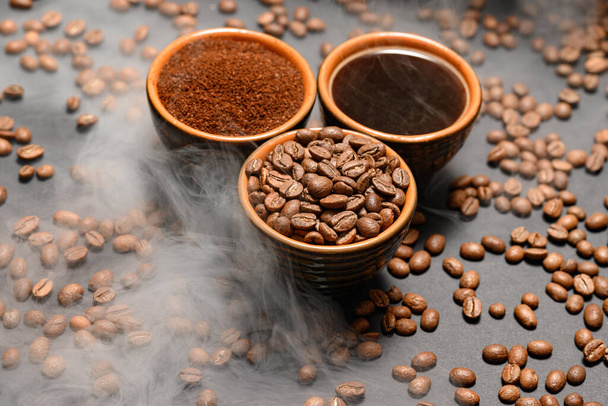 Set de tres tazas de granos de café, molido y bebida sobre fondo negro, vista superior del café. - Foto, imagen