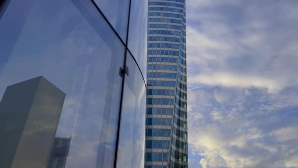 Lasipilvenpiirtäjät heijastavat sinistä taivasta pilvillä. Kameraliike modernilla liikealueella. Menestyksekäs liikeidea. Laadukas 4k kuvamateriaalia - Materiaali, video