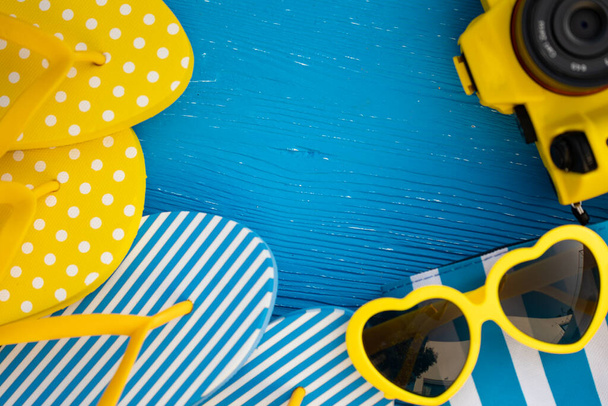 Beach flip-flops and sunglasses on blue wooden background. Summer vacation and travel concept concept - Photo, image