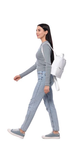 Woman with leather bag walking on white background - Φωτογραφία, εικόνα