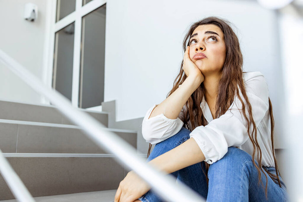 Worried young business woman at stairs office. Businesswoman looking stressed out in office. Woman looking away and contemplation at work. Stress.  - 写真・画像
